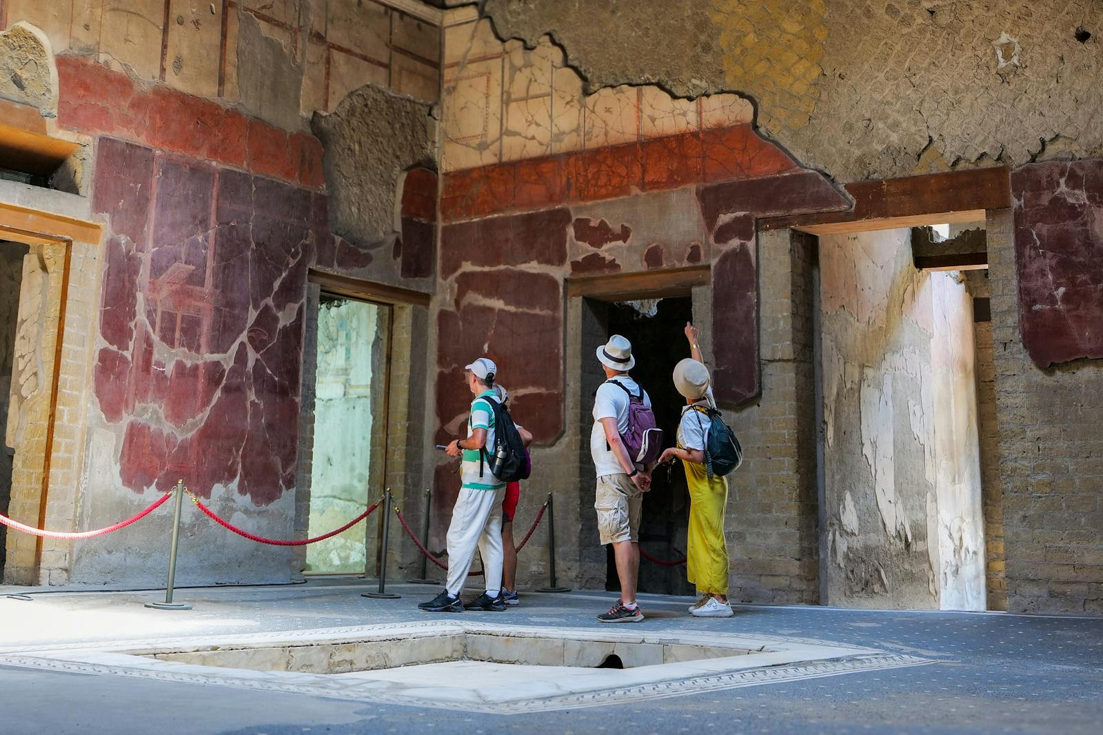 헤르쿨라네움 고대 벽화를 감상하는 방문객들