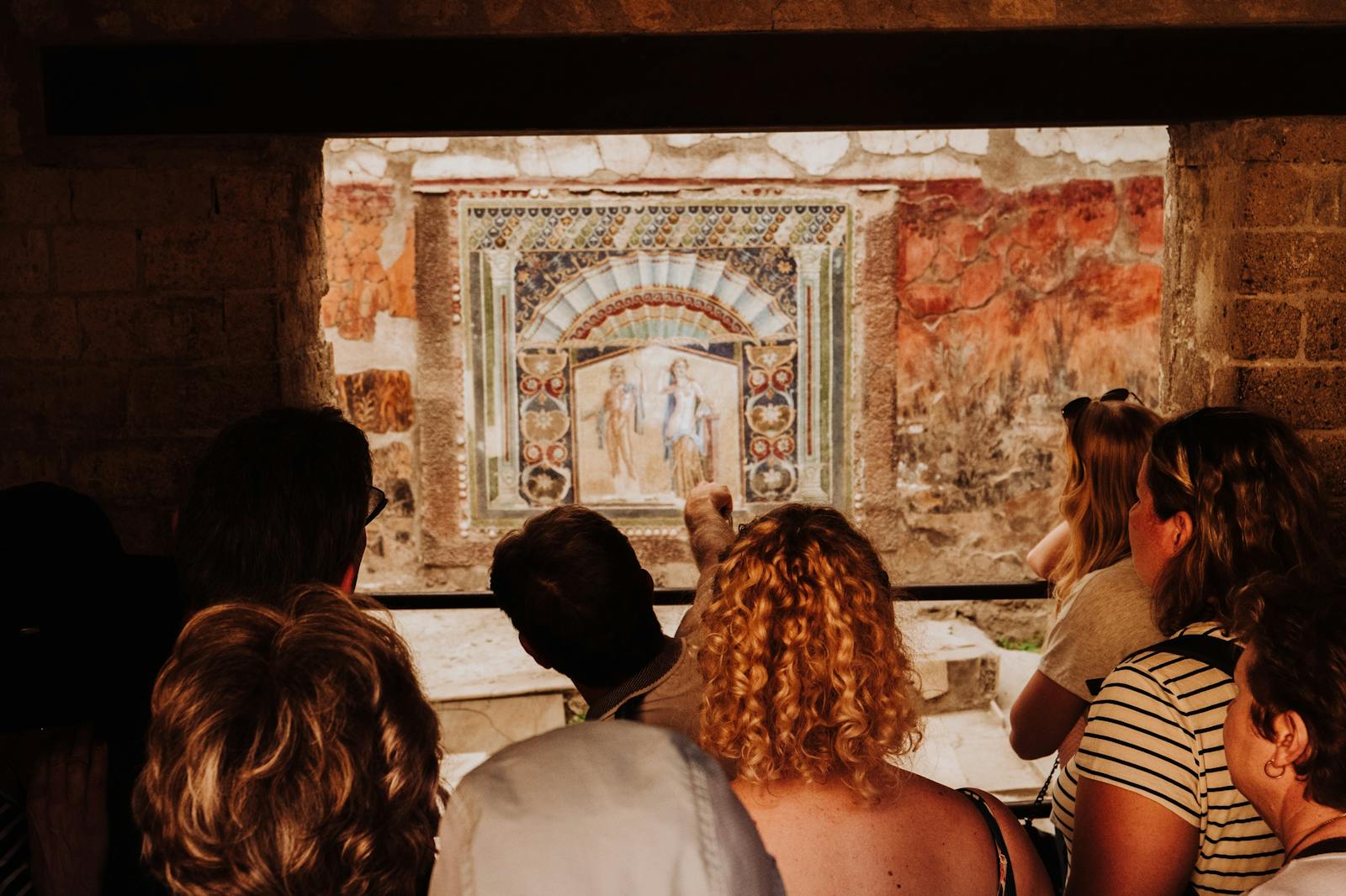 Turysci podziwiający starożytny fresk w Herculaneum